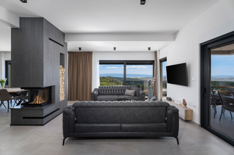 a fully A/C stylish living room with two sofas (both convertible into beds if needed), a fire place, a flat screen TV, a free WiFi