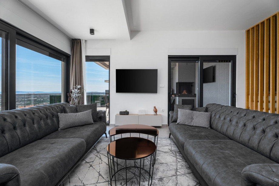 a fully air-conditioned stylish living room with two sofas (both convertible into beds if needed), a fire place, a flat screen TV, a free WiFi