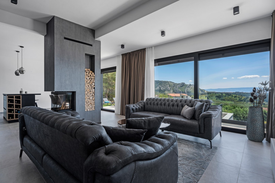 a fully air-conditioned stylish living room with two sofas (both convertible into beds if needed), a fire place, a flat screen TV, a free WiFi