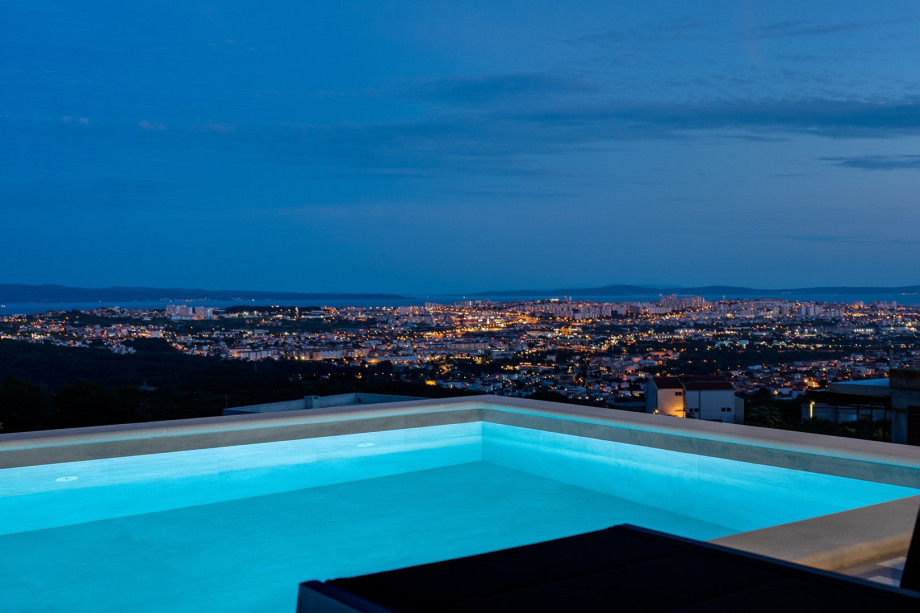 Pool area at night with a town view