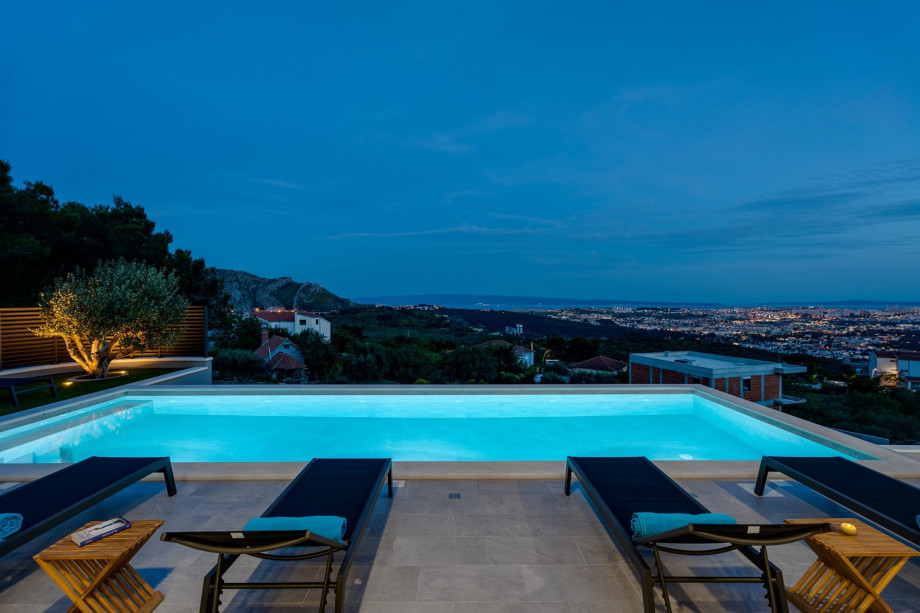 Pool area at night with a town view