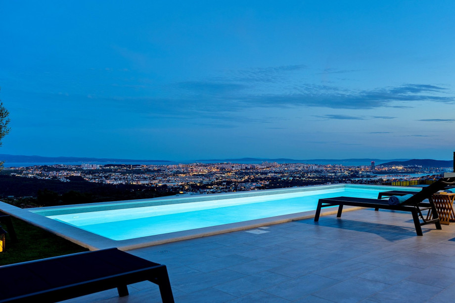 Pool area at night with a town view