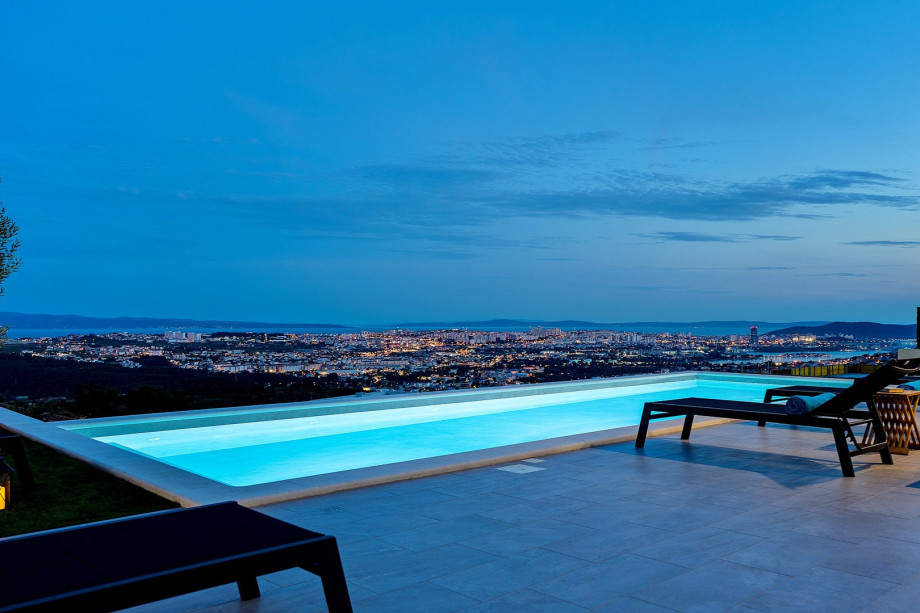 Pool area at night with a town view