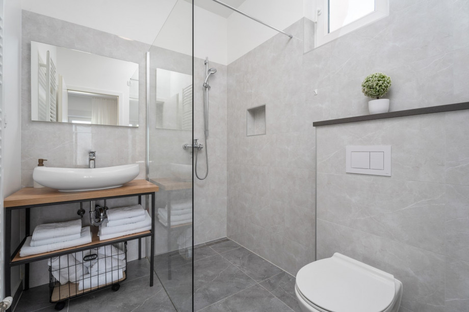 An en-suite bathroom with a shower, a sink, and a toilet
