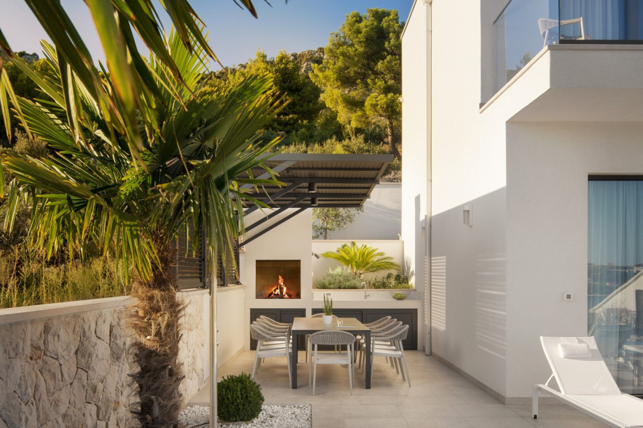 An outdoor dining area, and a traditional barbecue next to it