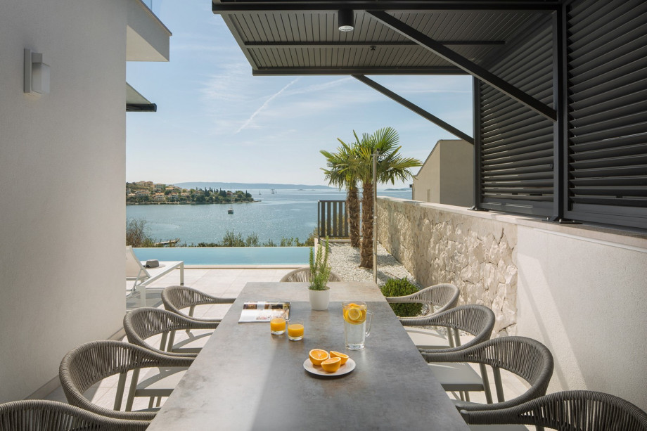 A covered terrace with a comfortable outdoor dining area