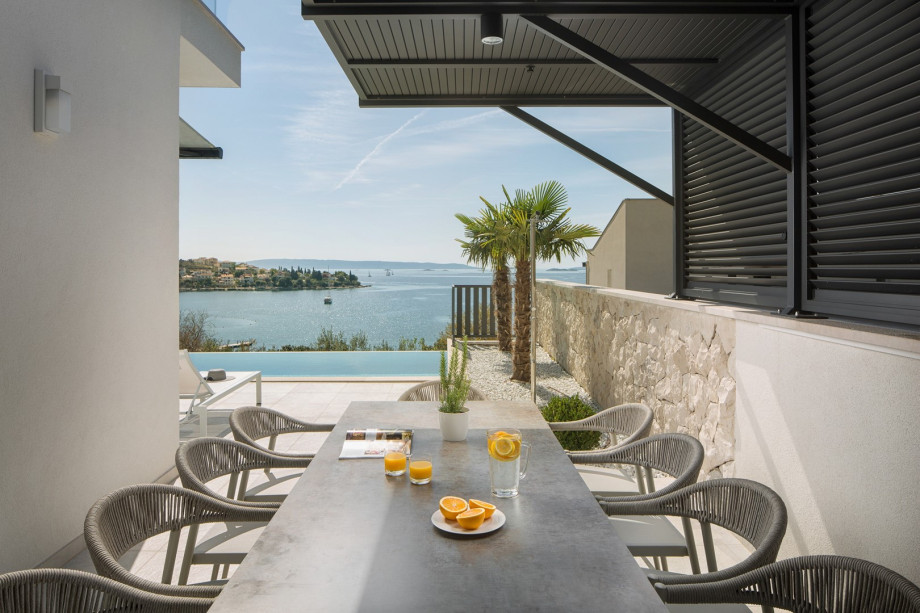 A covered terrace with a comfortable outdoor dining area