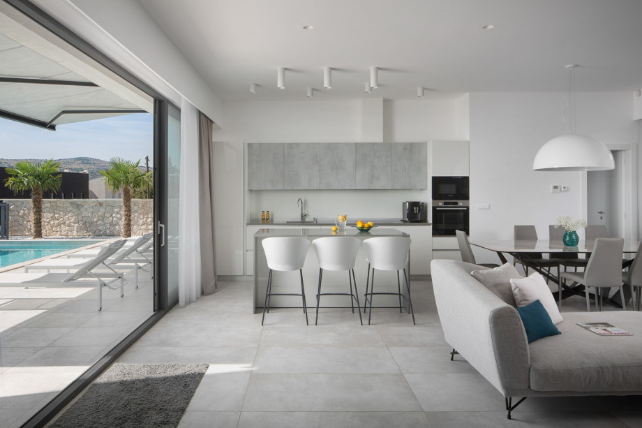 A fully equipped kitchen with a spacious kitchen island with stools, a coffee maker, a microwave oven, and everything you need to cook