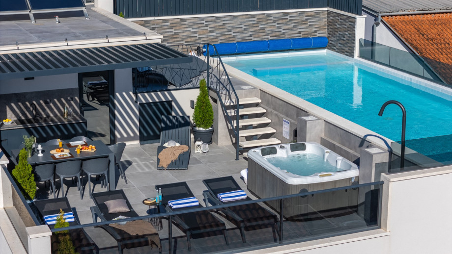 Rooftop terrace with a 40,7sqm heated pool, whirlpool, lunge chairs, and outdoor shower