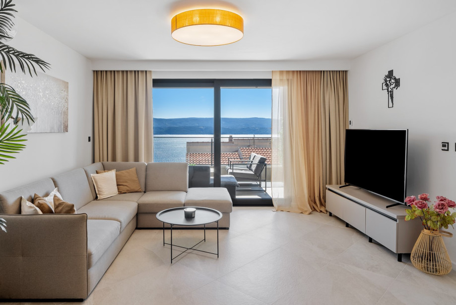 Stylish living room with sofa, flat screen TV, sliding doors to the covered 28sqm terrace