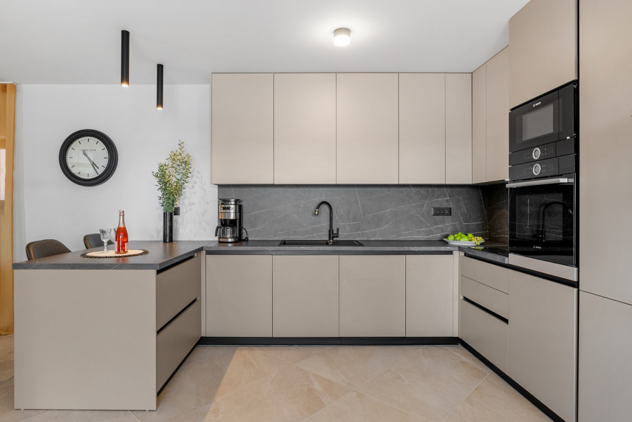 The kitchen is fully equipped with a kitchen island, a microwave, an oven, a filter coffee machine, a dishwasher...