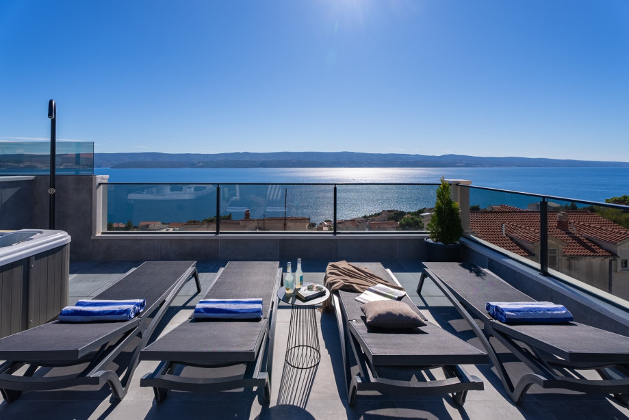 Rooftop terrace featuring a heated swimming pool, whirlpool, and outdoor dining area