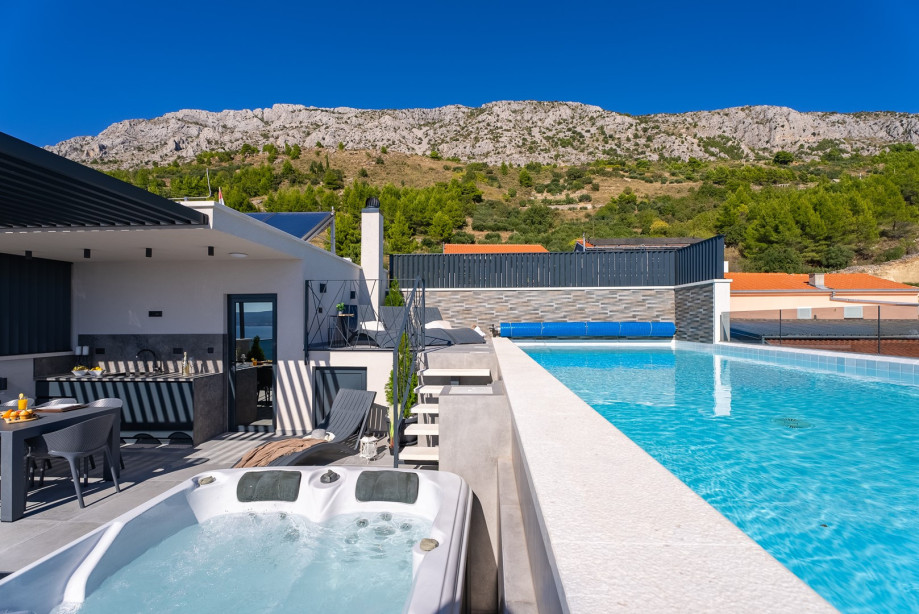 Rooftop terrace featuring a heated swimming pool, whirlpool, and outdoor dining area