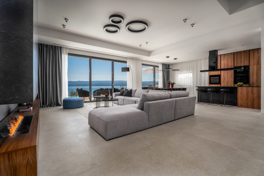 Living area with a water vapor fireplace, very comfortable sofa, a flat-screen smart TV, Sonos speakers, A/C, and free WiFi.