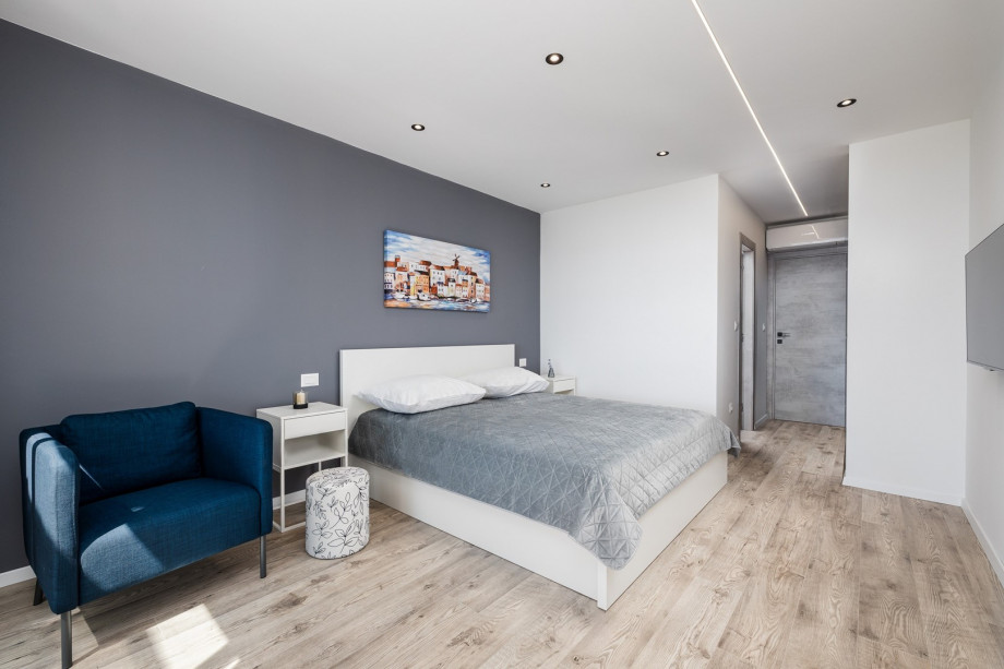 Bedroom No2 with an exit to a balcony with outdoor furniture, sea views and views of the town Split