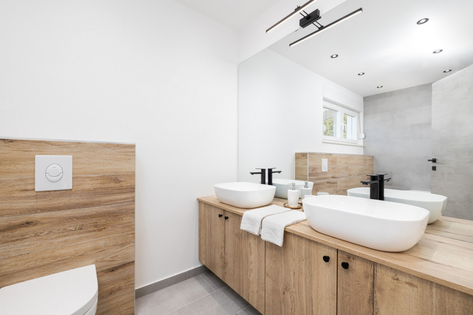 En-suite bathroom with a toilet and a bathtub, two sinks