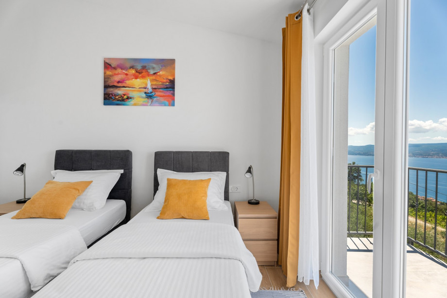 Third bedroom is 13 square meters and has two 90-by-200-cm single beds, a TV, air conditioning, a balcony, and views of the sea.