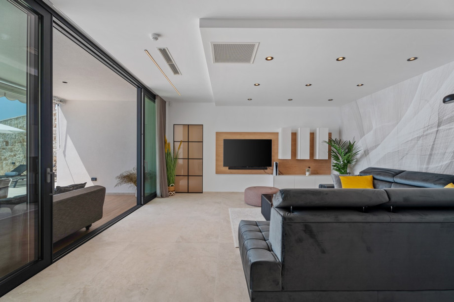 Large glass walls connecting the villa’s ground floor interior with the exterior