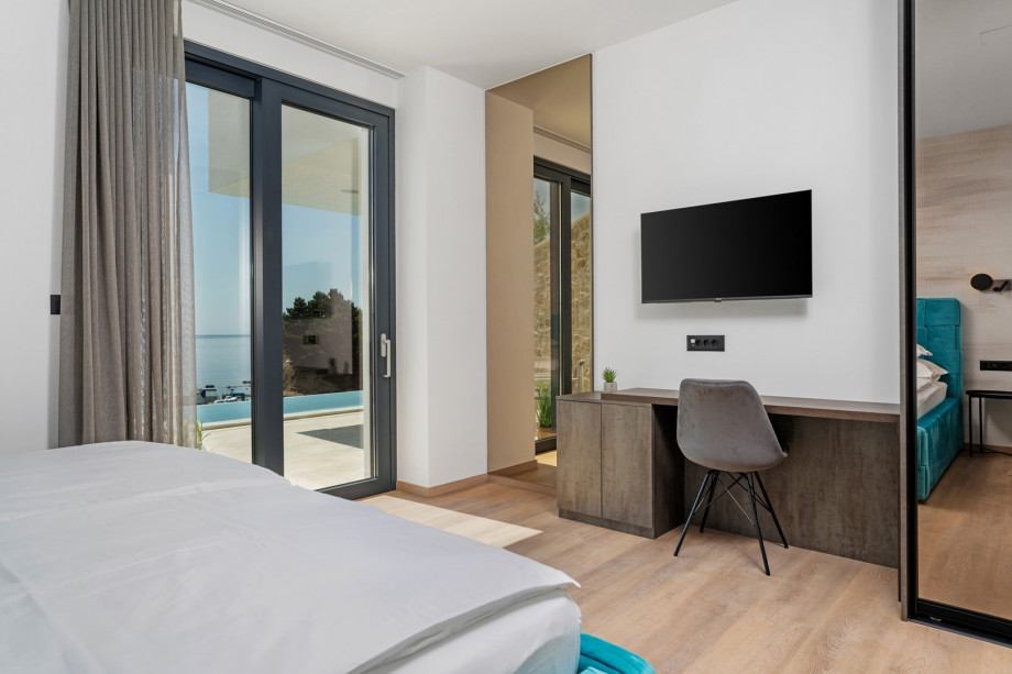 Bedroom No1 (23sqm) is located on the ground floor and has a direct exit toward the pool area and a sea view