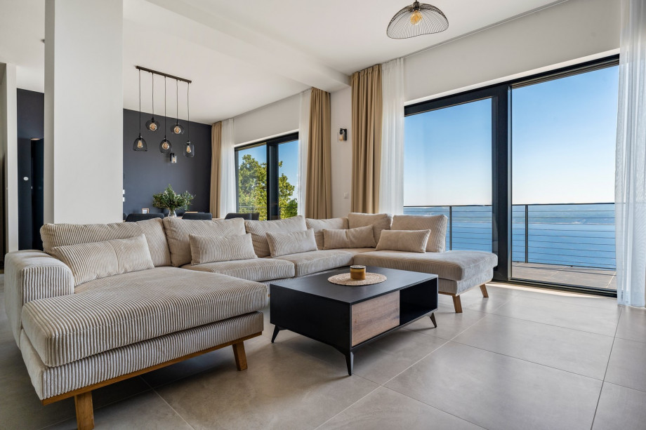 Spacious living/dining room with glass walls that give you a beautiful view of the sea and lots of daylight inside