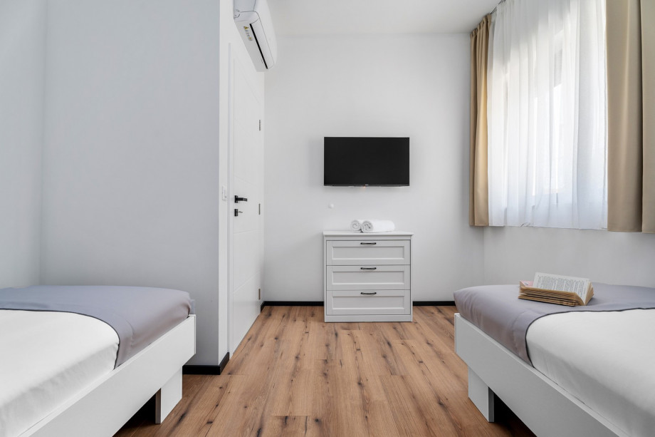 Bedroom NO3 (12sqm) with two single beds 90cm x 200cm, TV, A/C, views of the pool area on the west side.