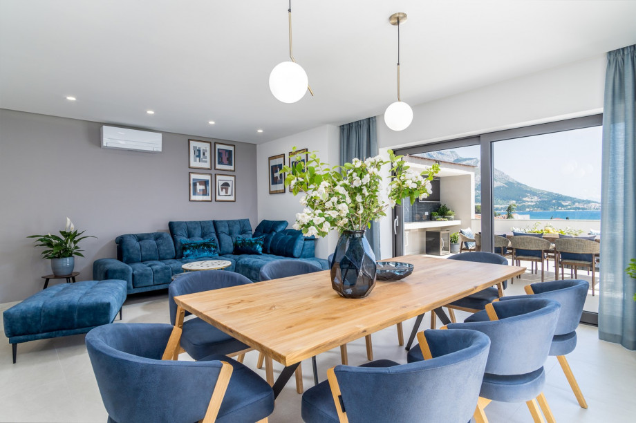 A living and dining area overlooking the pool and sea