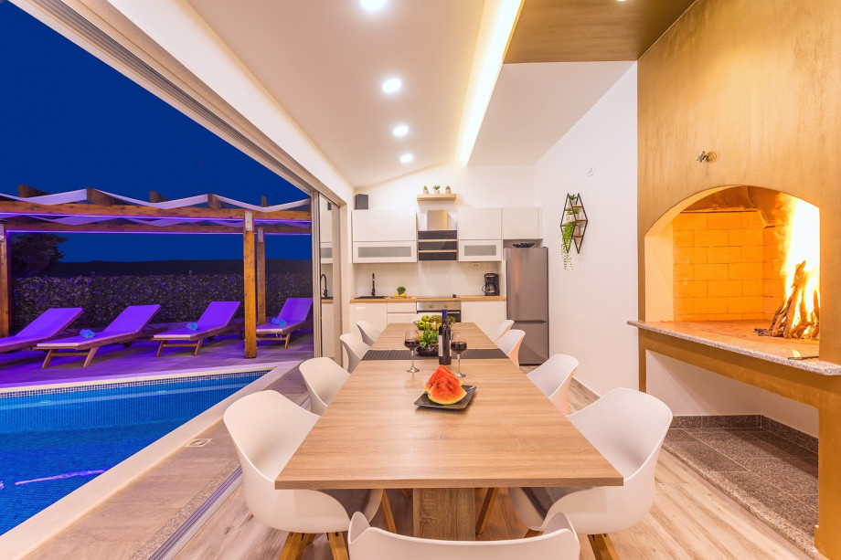 Fully equipped summer kitchen with a traditional grill, dining area, toilet