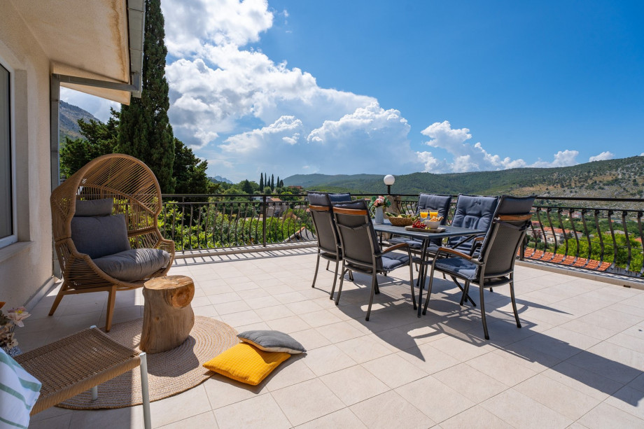 Spacious terrace in front of the living room with outdoor furniture and open panoramic view