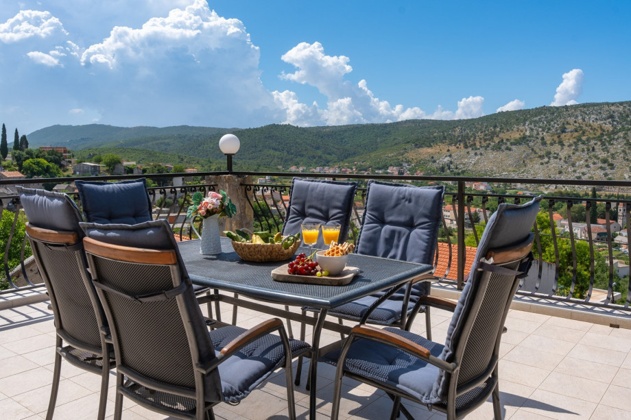 Spacious terrace in front of the living room with outdoor furniture and open panoramic view