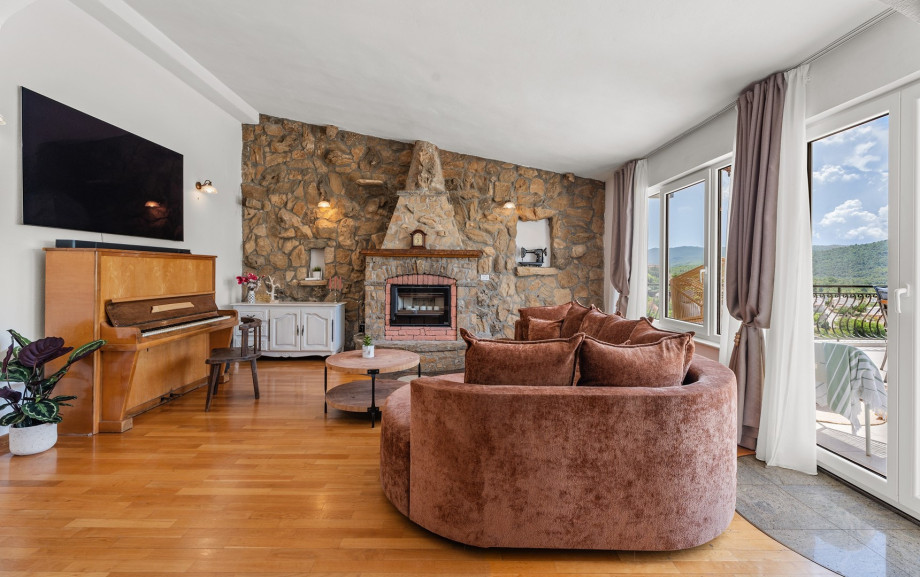 Living area with piano, fireplace and exit to terrace
