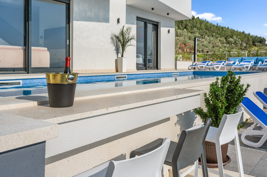 Enjoy, a bar with three bar stools, also accessible from the inside of the pool.