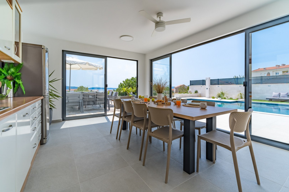 Fully equipped summer kitchen (40sqm) with the outdoor dining area with a ceiling fan, a traditional barbecue