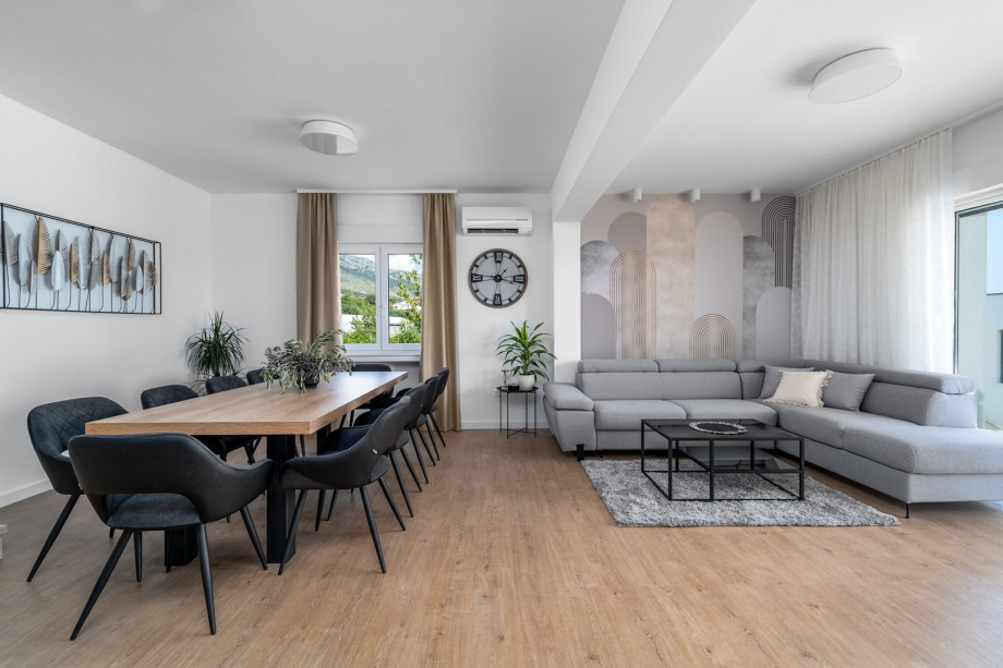 The ground floor offer dining table, a living room with a comfortable sofa and glass doors toward the pool area