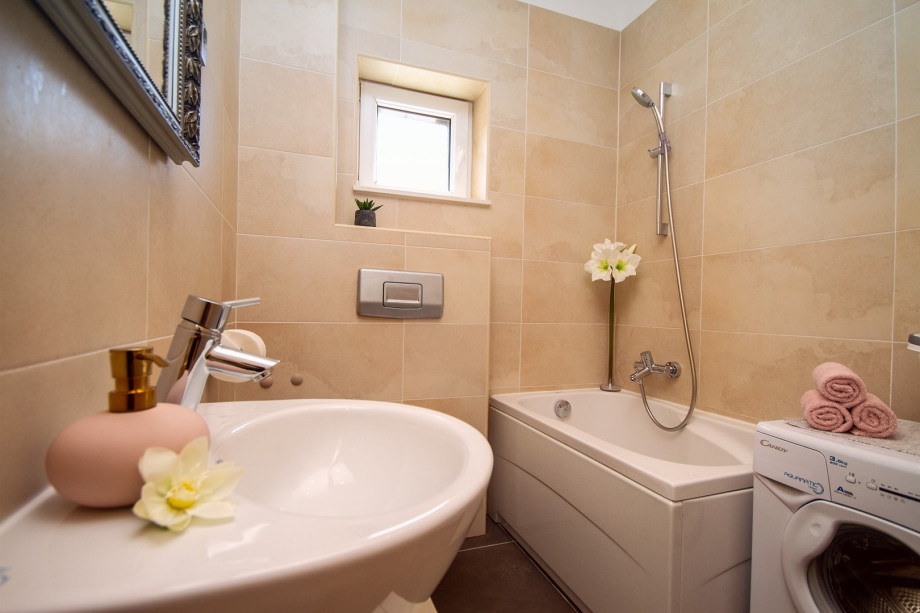 a family bathroom with a bathtub and a washing machine