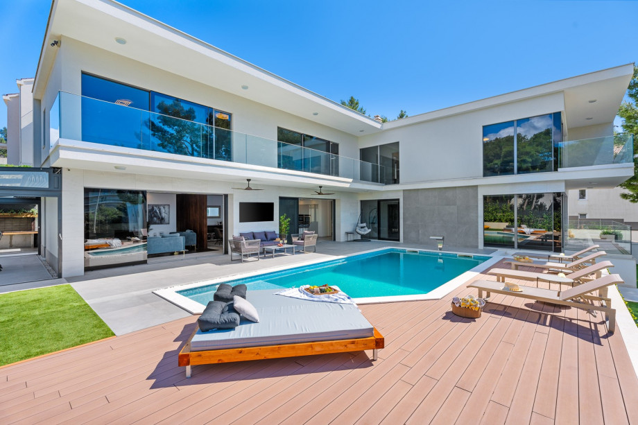 A lounge area in front of the living room, a projector that projects onto a wall, an outdoor shower