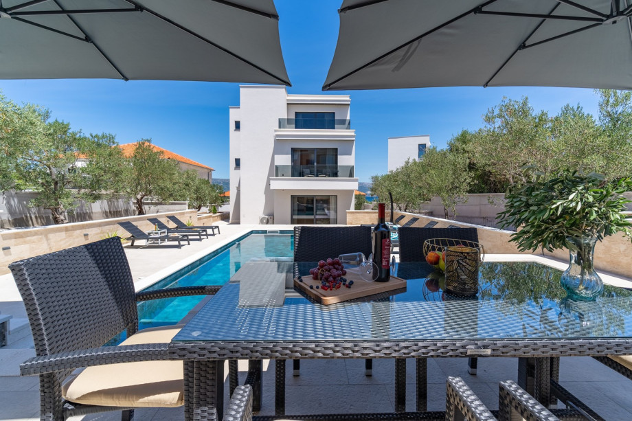 Spacious sun deck area with 10 deck chairs, an outdoor shower, a dining table and 2 sun umbrellas