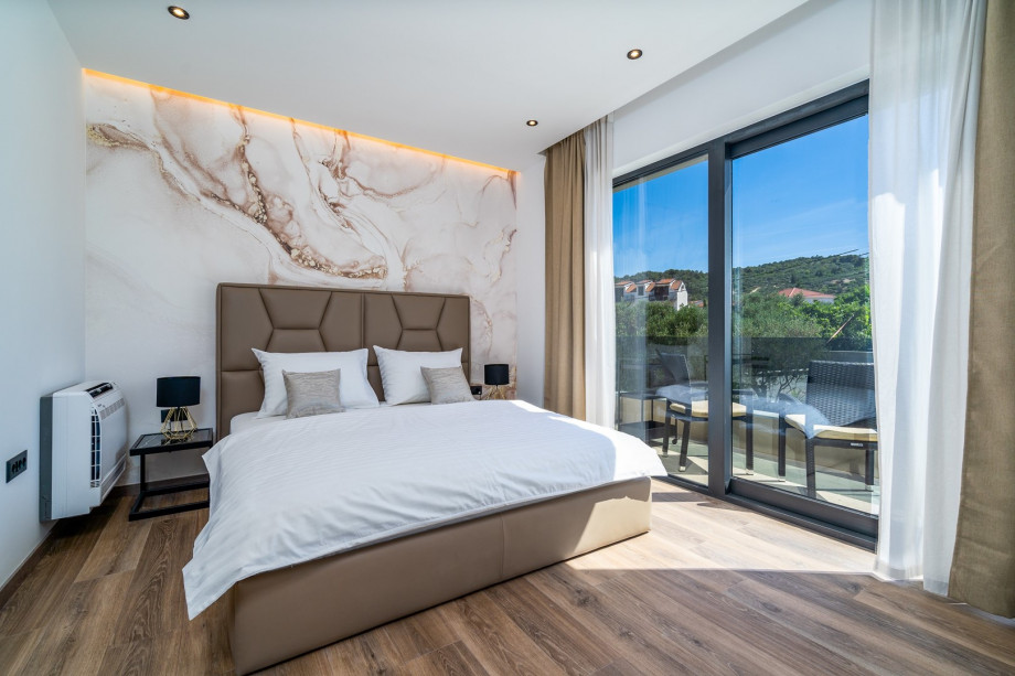 Bedroom No3 with king size bed 180cm x 200cm overviewing the pool, en-suite bathroom with a shower, air-conditioning and  balcony