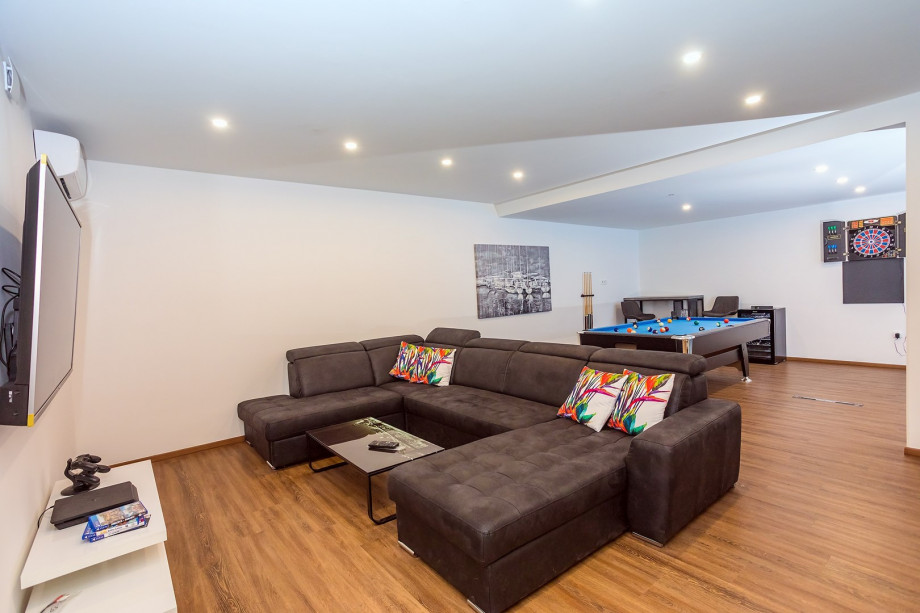 The basement offers a media room with a flat-screen TV, A/C, PS4, billiard table, Bluetooth speakers,