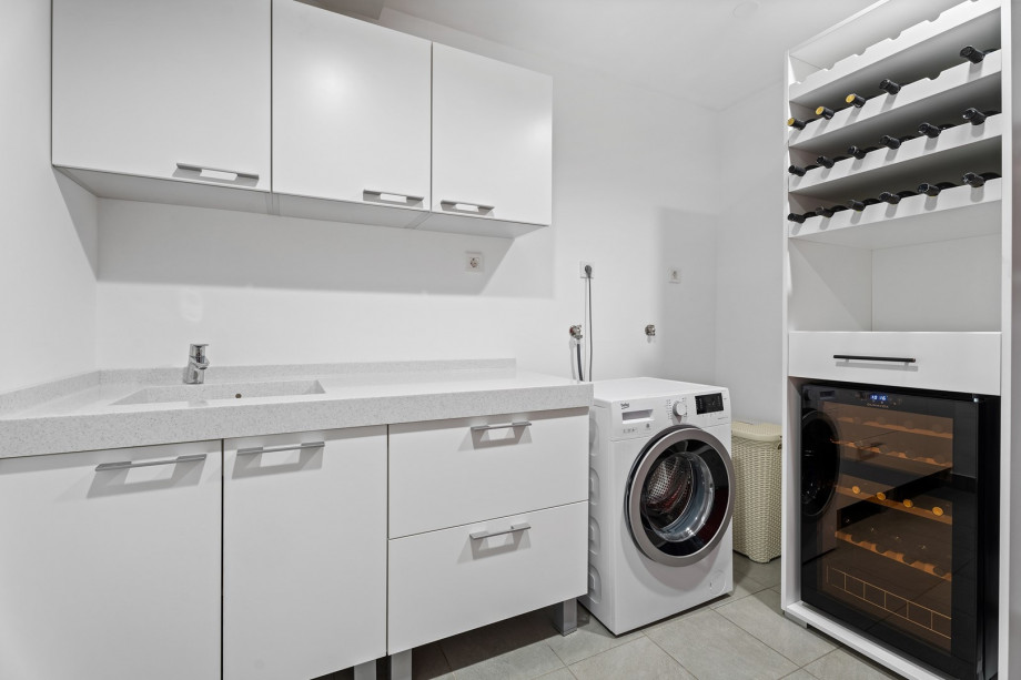 Laundry with washing machine, iron and iron board at the basement level.