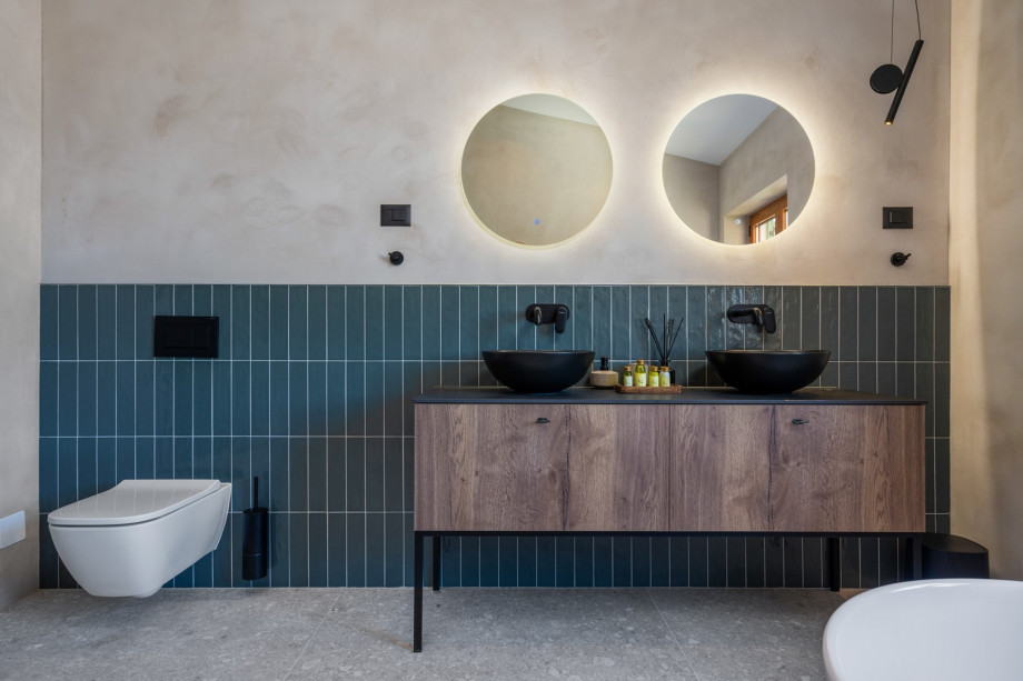 En-suite bathroom with a self-standing bathtub and a shower, a double sink, a toilet.