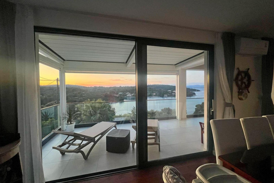 The living area features an exit to a newly roofed terrace, which overlooks a tranquil bay.