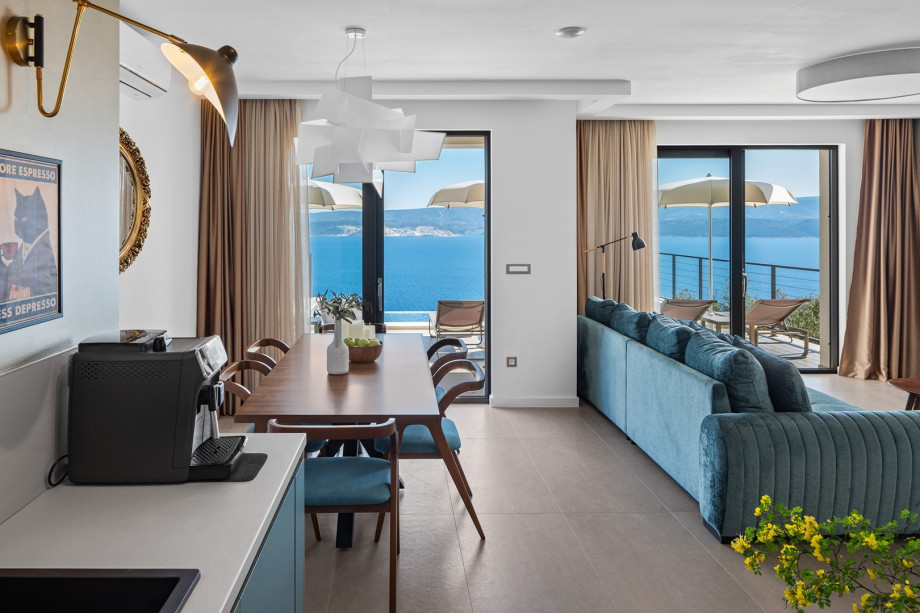 The living space is designed with large glass doors that flood the space with natural light and connect you to the pool and sea views