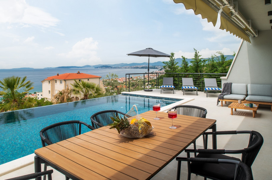In front of the dining/living room are a covered dining area for 8 people and a very comfortable lounge corner, all with sea views.