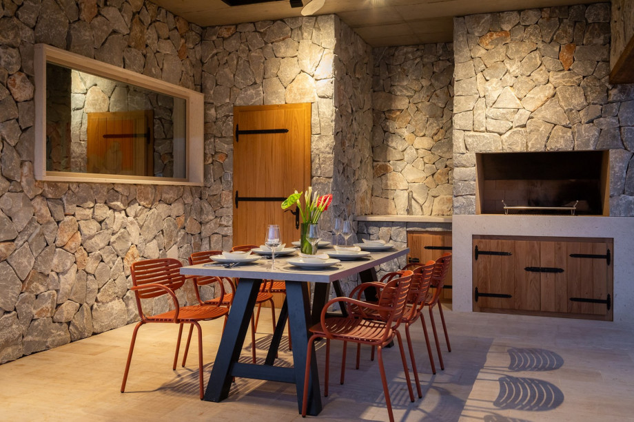 There is a covered outdoor dining area with a barbecue
