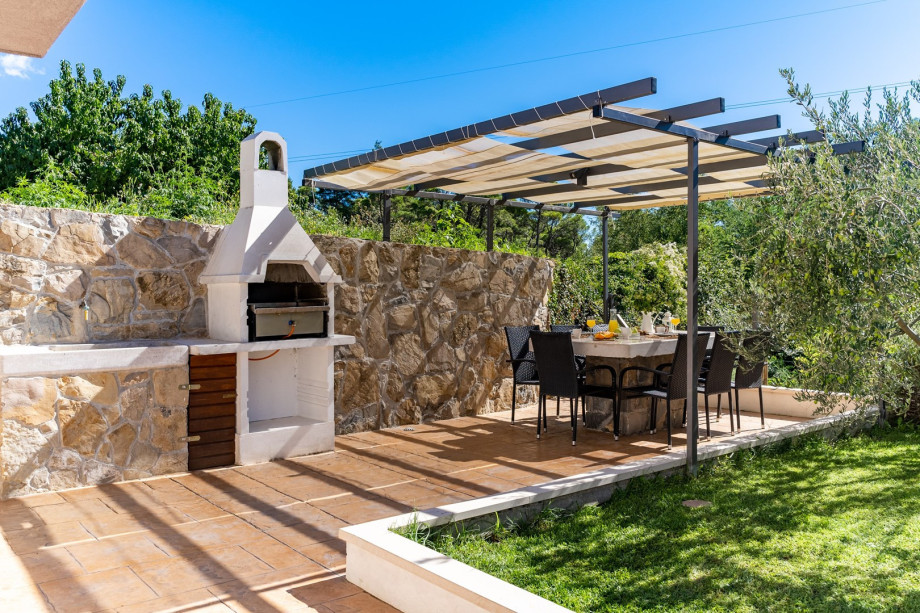 Covered outdoor dining area with a gas barbecue