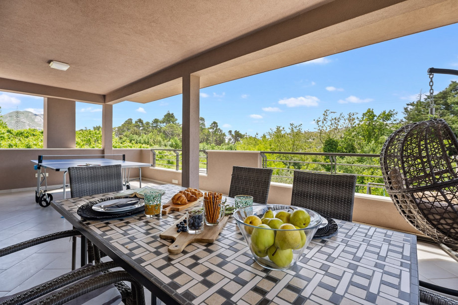 A terrace with an outdoor dining area and table tennis