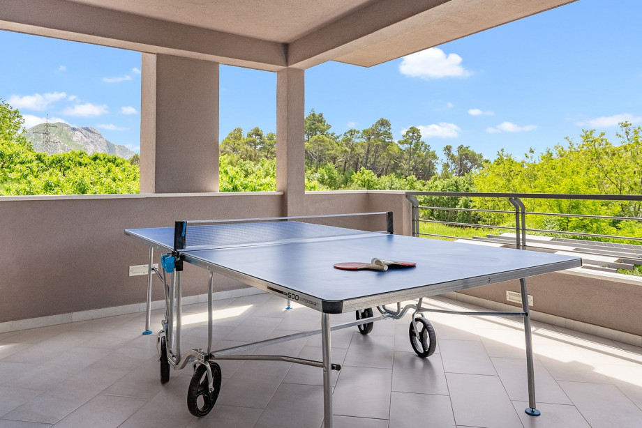 A terrace with an outdoor dining area and table tennis