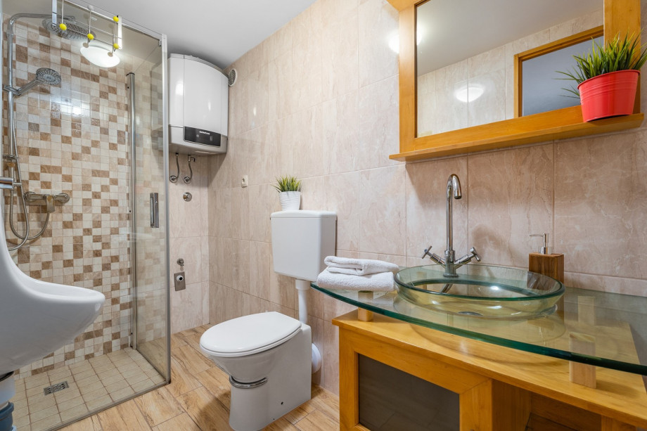 A bathroom with a shower, a sink, and a toilet