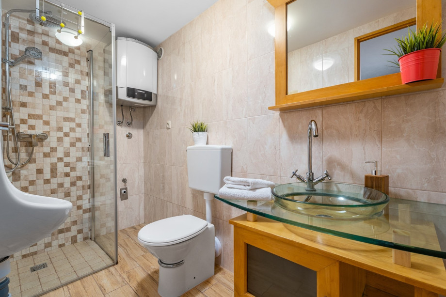 A bathroom with a shower, a sink, and a toilet