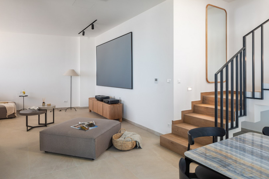 Fully furnished living area with sofa, a projector with the receiver (as a TV)